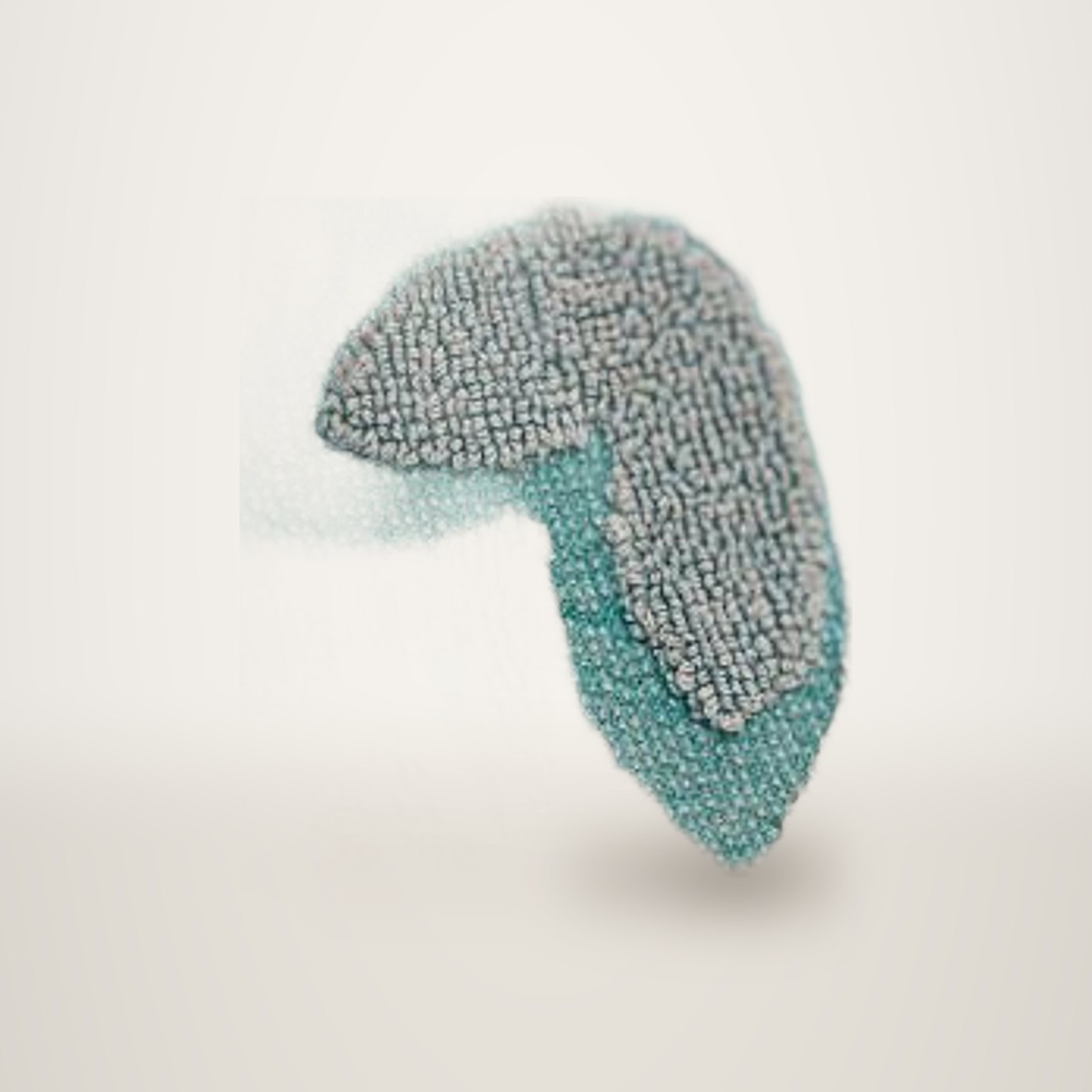 Gros plan sur une serviette éponge turquoise ornée de motifs floraux en relief de couleur grise.