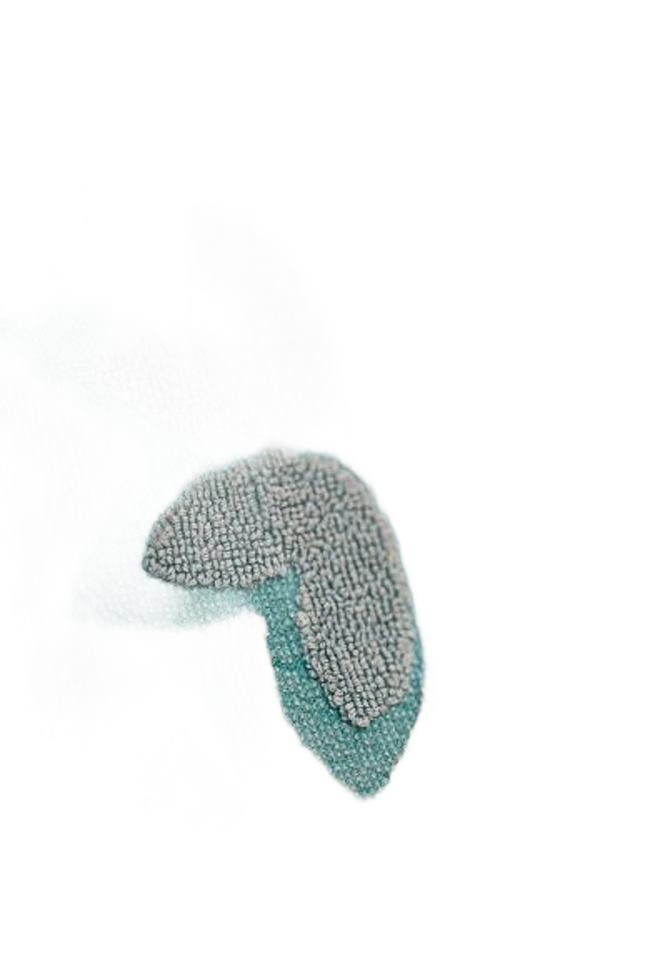 Gros plan sur une serviette éponge turquoise ornée de motifs floraux en relief de couleur grise.