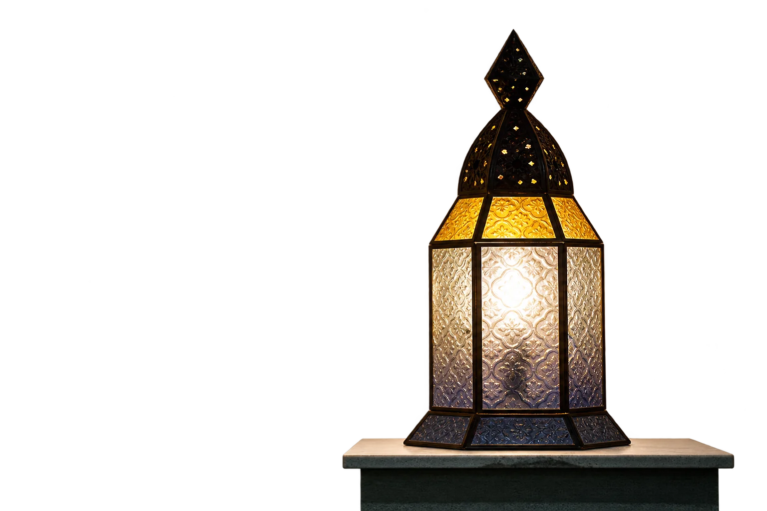 Une lanterne orientale en métal et verre texturé jaune et bleuté, allumée, posée sur un socle blanc dans une pièce sombre.